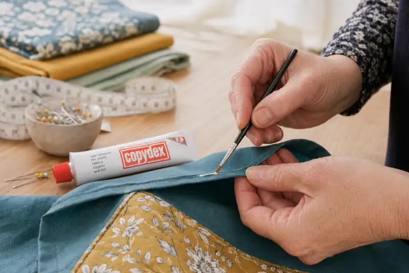 Copydex adhesive applied to a fabric hem for no-sew dressmaking UK