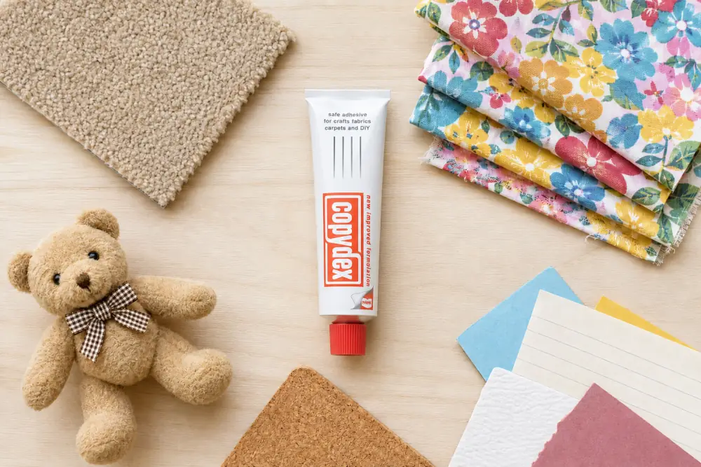 Copydex adhesive 50ml bottle with carpet, fabric, teddy bear, cork and paper craft materials UK